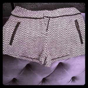 Black and white designer shorts trimmed in leather